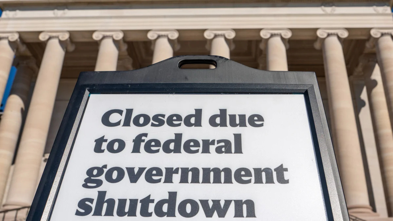 Image of the Capitol building. There is a sign in front of it that reads 'Closed due to federal government shutdown'.